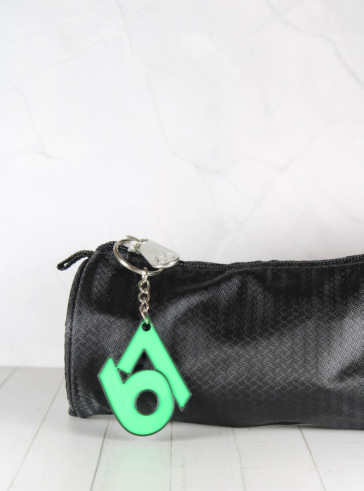 Porte-clé 67 vert et noir accroché à une trousse