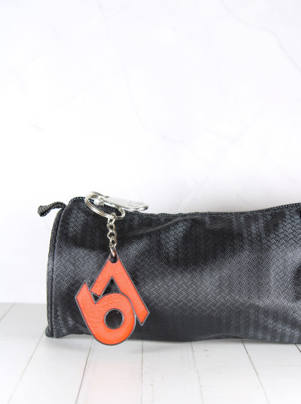 Porte-clé 67 rouge et noir accroché à une trousse