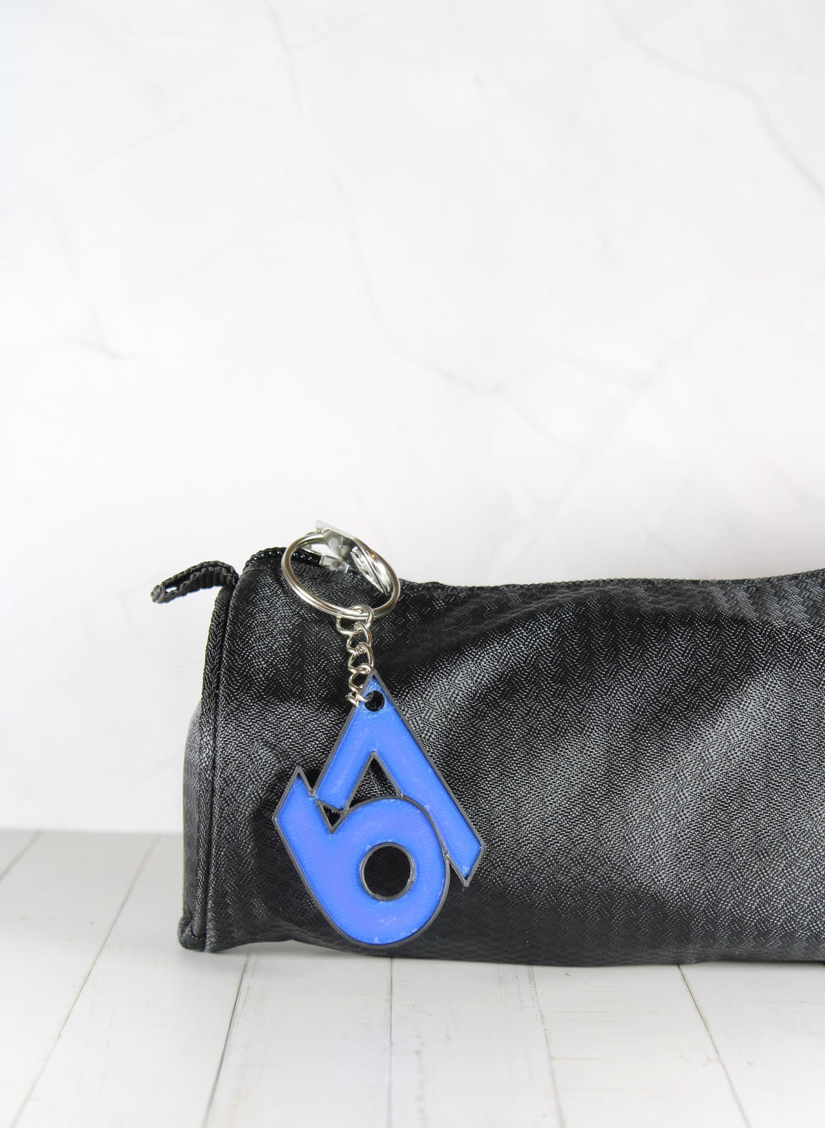 Porte-clé 67 bleu et noir accroché à une trousse