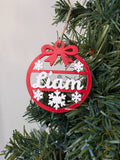 Boule de Noël personnalisée avec prénom Liam, ornement de sapin rouge et blanc avec flocons, fabriqué en impression 3D.