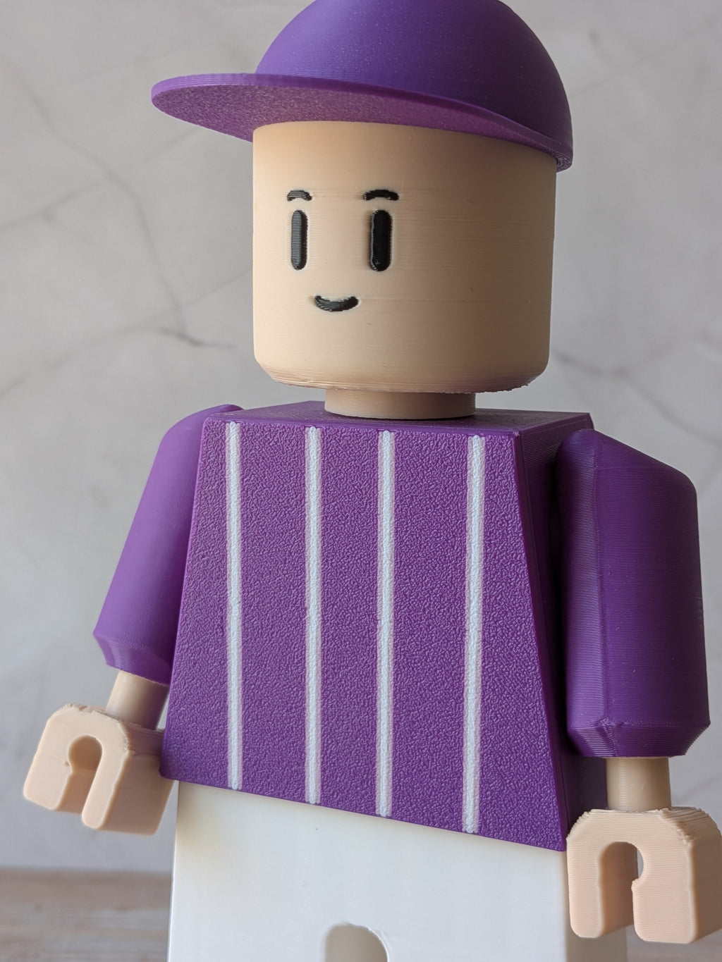 Détail de la casquette et de la tenue violette de la figurine football Toulouse