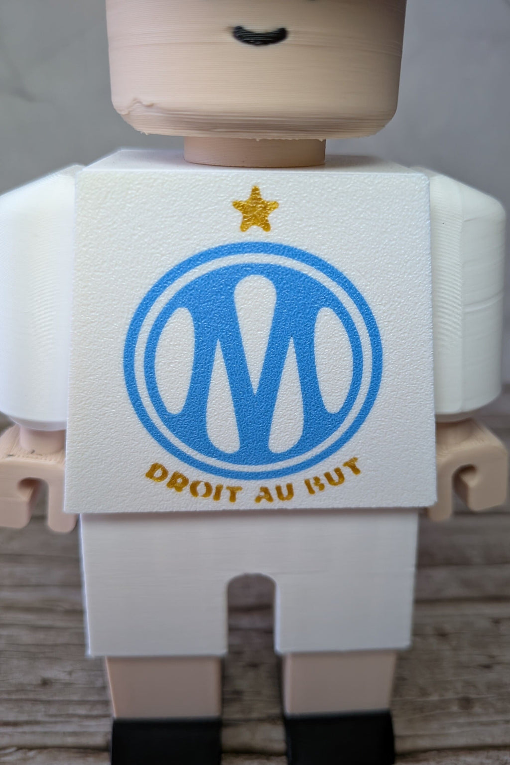 impression-3d.jpg
Détail du logo sur figurine inspirée de l'OM imprimée en 3D