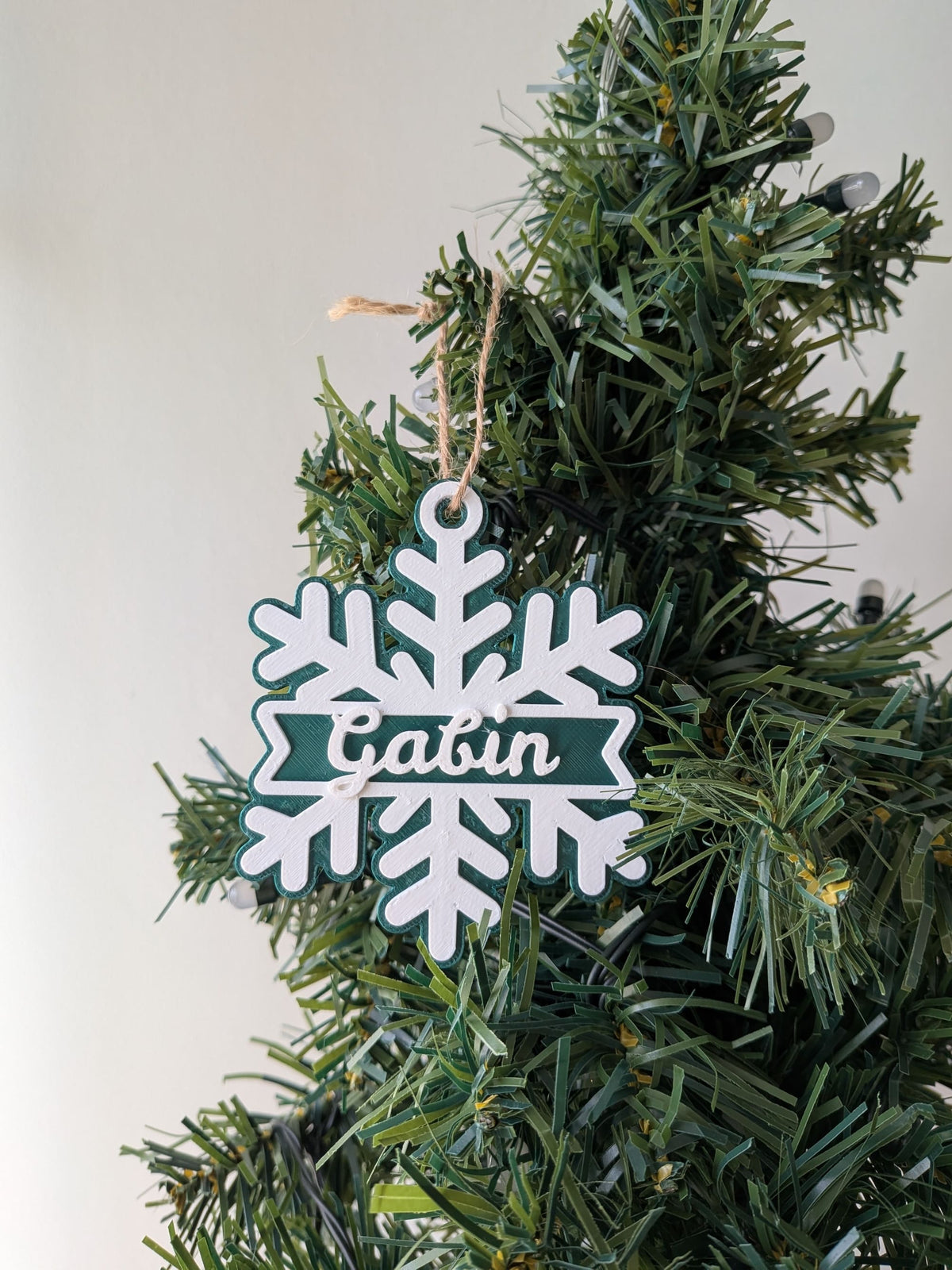 Flocon de neige vert et blanc avec prénom Gabin en relief, décoration de sapin de Noël personnalisée.
