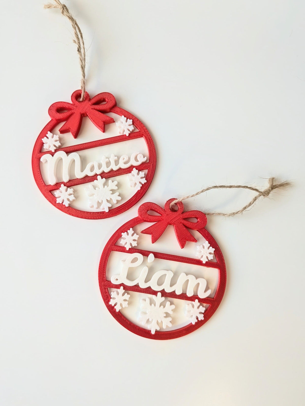 Lot de deux boules de Noël personnalisées avec prénoms Liam et Matteo, décorations rouges et blanches à suspendre au sapin.