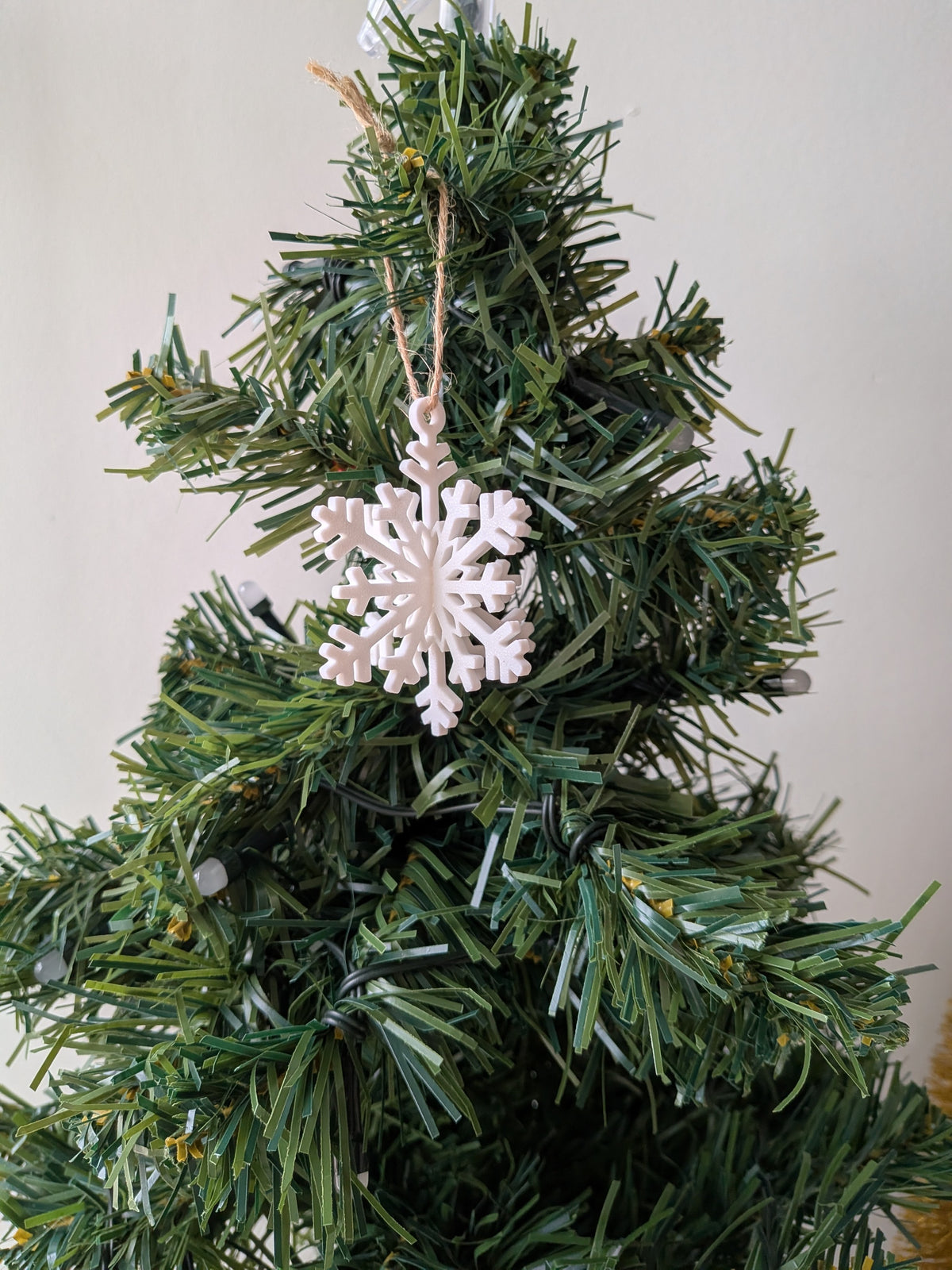 Ornement flocon de neige blanc suspendu dans un sapin de Noël