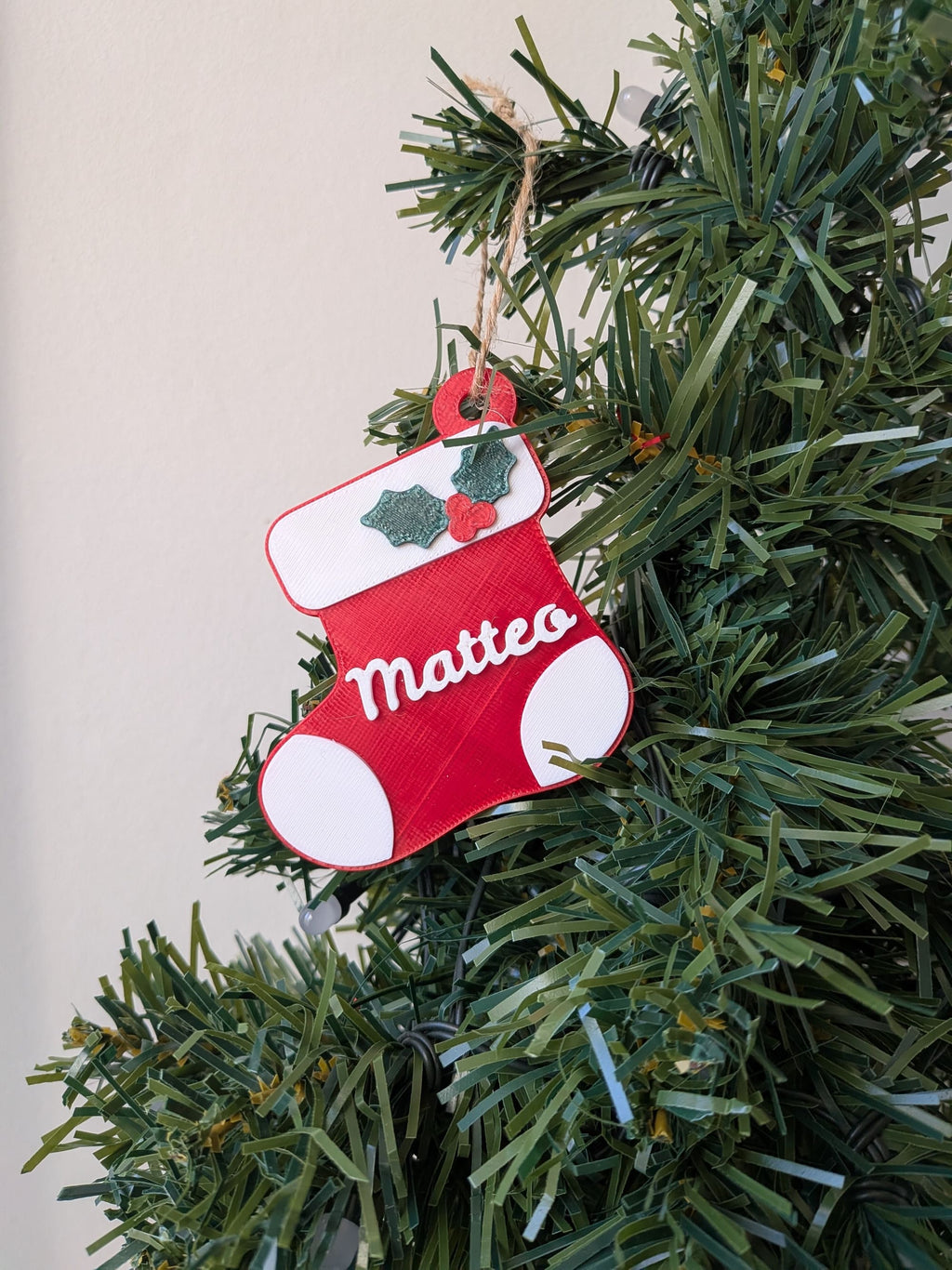 Ornement de sapin en forme de chaussette de Noël rouge et blanche avec le prénom Matteo personnalisé en relief.