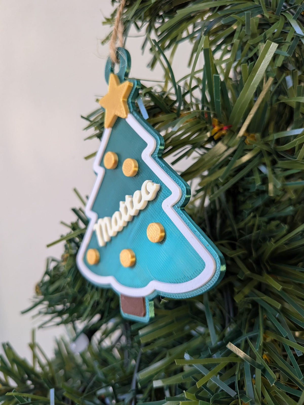 Vue de profil d'un ornement sapin de Noël personnalisé, montrant le prénom Matteo, l'étoile et les décorations en relief imprimés en 3D.